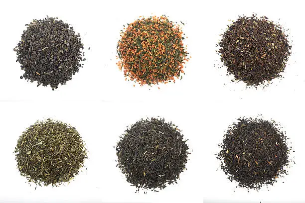 teas shot from above side in studio. from left above to right below: gunpowder tea (green tea), genmaicha tea (rice tea, green tea), darjeeling tea (black tea), sencha tea (green tea), white tea, jasmine tea