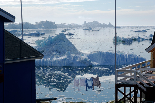 Washing hanging to dry against the backdrop of the Arctic icebergs of the Ilulissat Icefjord, Greenland