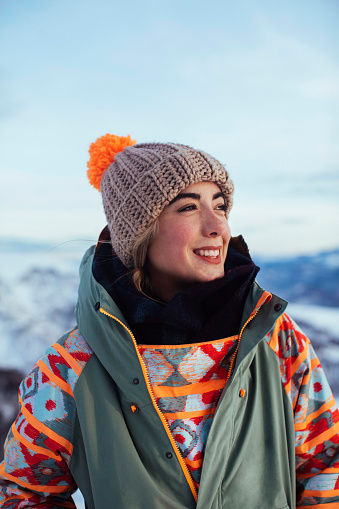 Young woman laughs as he poses for a portrait on the mountain