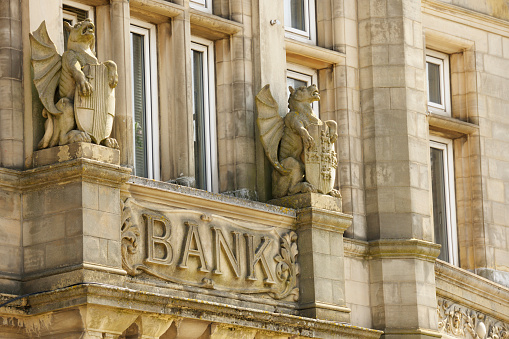 Bank Sign on Old Building Protected by Stone Gryphons