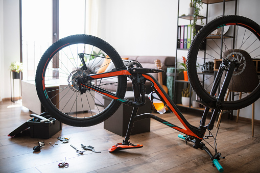 Shot of inverted bicycle in a living room for repair.