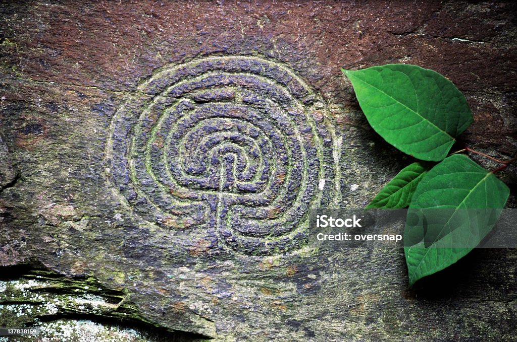 Ancient Carved Maze Ancient carved (petroglyph) maze into the naturally colored and textured stone cliff face in Rocky Valley, near Tintagel, Cornwall, England Maze Stock Photo
