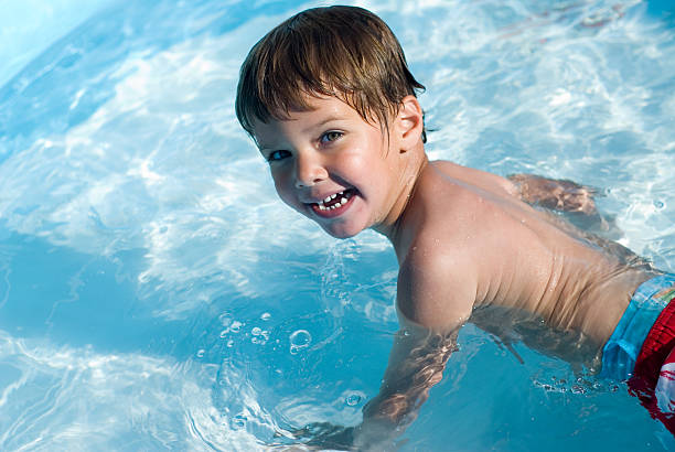 Little boy in pool stock photo