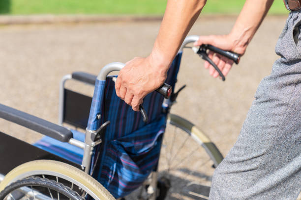 Asian elderly man pushing a wheelchair, hands