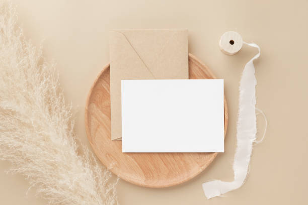 istock Blank greeting card invitation Mockup on Brown envelope with pampas grass on beige background, Minimal table workplace composition, flat lay, mockup 1378430956