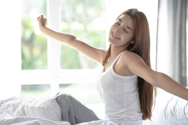 istock Woman waking up and stretching on bed 1378431781