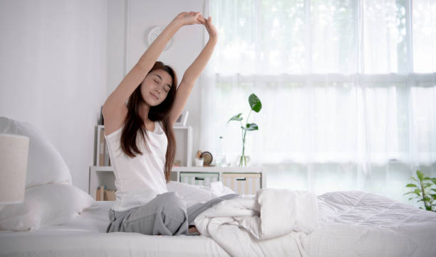 istock Woman waking up and stretching on bed 1378431825