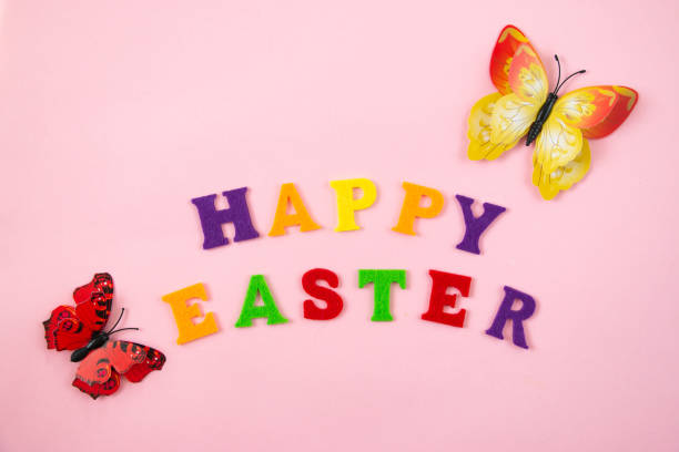 istock Easter eggs, colorful letters and butterflies on a pink background. Happy easter concept. Festive background, flat lay. 1378443777