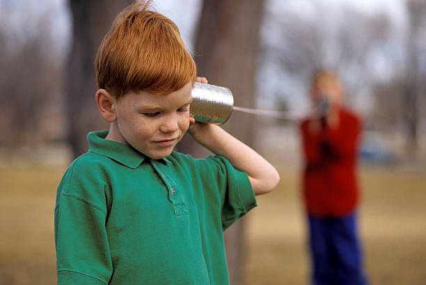 meninos brincando em um pode telefone - telephone can communication tin can phone - fotografias e filmes do acervo