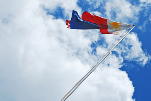 Philippine Flag Waving Against the Wind Over Blue Skies