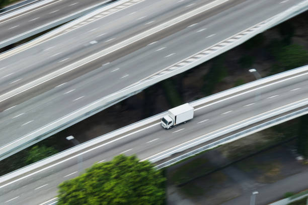 camion bianco che guida su strada sopraelevata - moving van truck delivery van van foto e immagini stock