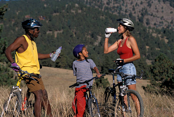 Family of three enjoying a day of mountain-biking together stock photo