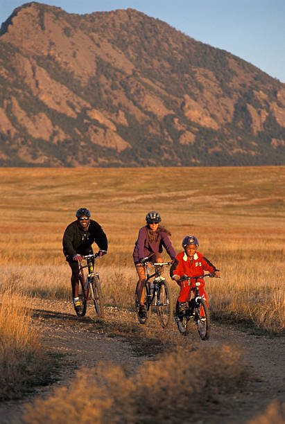 A family of three mountain biking together stock photo
