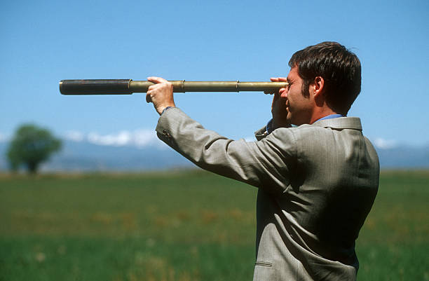 istock Businessman with telescope in open field 137852546