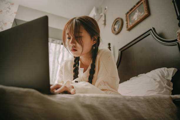 istock A beautiful asian girl who works on a computer in bed 1378566005