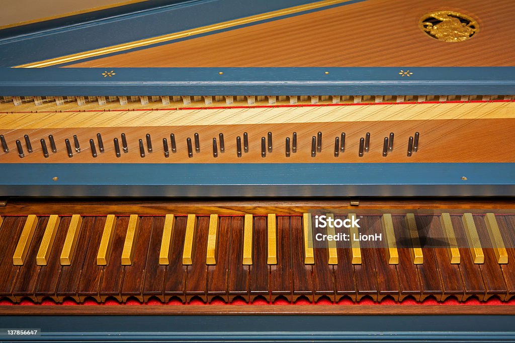Blue spinet (harpsichord) with brown wooden keyboard Blue open harpsichord with dark and light wooden keyboard; selective focus on the keys. Harpsichord Stock Photo