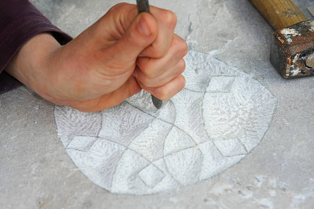 istock Sculptor making ornament on a stone monolith 137861050