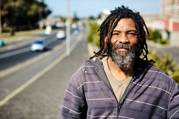 sans-abri avec barbe et dreadlocks à l’extérieur en ville par temps ensoleillé - tramp photos et images de collection