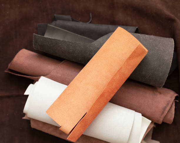 istock Professional crafter choosing cow leather in roll for making leather items 1378686335