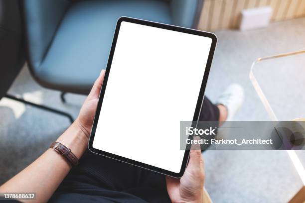 Mockup Image Of A Woman Holding Digital Tablet With Blank White Desktop Screen In Cafe Stock Photo - Download Image Now