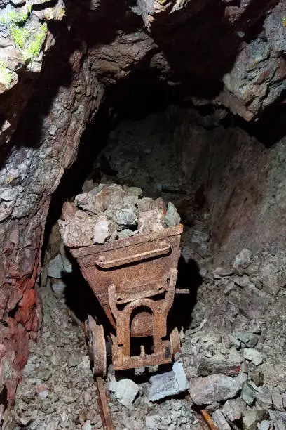 Photo of Old abandoned ore mine. Rusty trolley. Extraction of minerals.