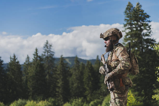 istock War concept. A bearded soldier in a special forces uniform fighting an enemy in a forest area. Selective focus 1378702940