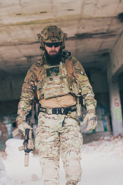 istock A bearded soldier in a special forces uniform walks through an abandoned building after a successful mission. Selection focus 1378718440