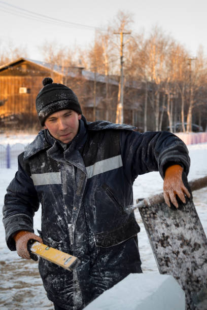 istock Builder with a tool in his hands at the construction site of the ice town 1378718446