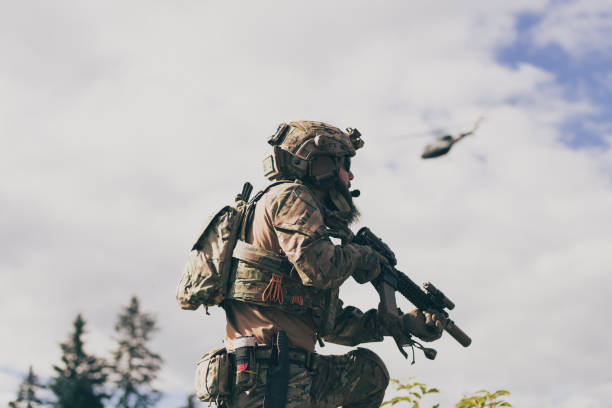 istock War concept. A bearded soldier in a special forces uniform fighting an enemy in a forest area. Selective focus 1378726425