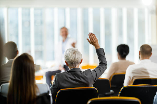 istock Back view of a businesswoman asking a question on a seminar. 1378733041