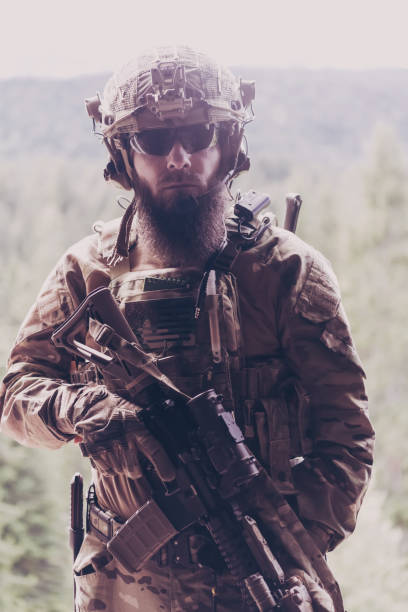 istock War concept. A bearded soldier in a special forces uniform fighting an enemy in a forest area. Selective focus 1378746476