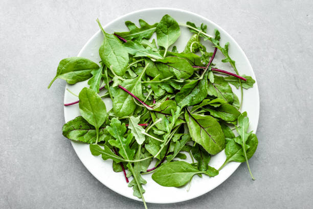 mezcla de ensalada verde fresca con espinacas, rúcula y hojas de remolacha en el plato, vista superior - beet green fotografías e imágenes de stock