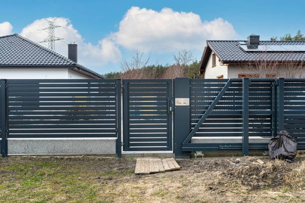 istock Modern panel fencing in anthracite color, visible spans and a gate with a letterbox, view from the garden. 1378753528
