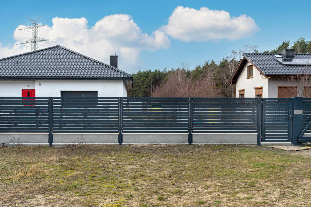 istock Modern panel fencing in anthracite color, visible spans and a gate with a letterbox, view from the garden. 1378754071