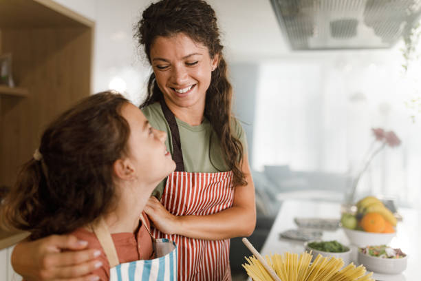 istock Happy mother and daughter making lunch in the kitchen. 1378758966