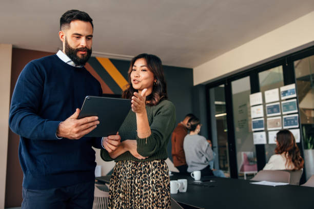 istock Two businesspeople using a digital tablet in a boardroom 1378765437