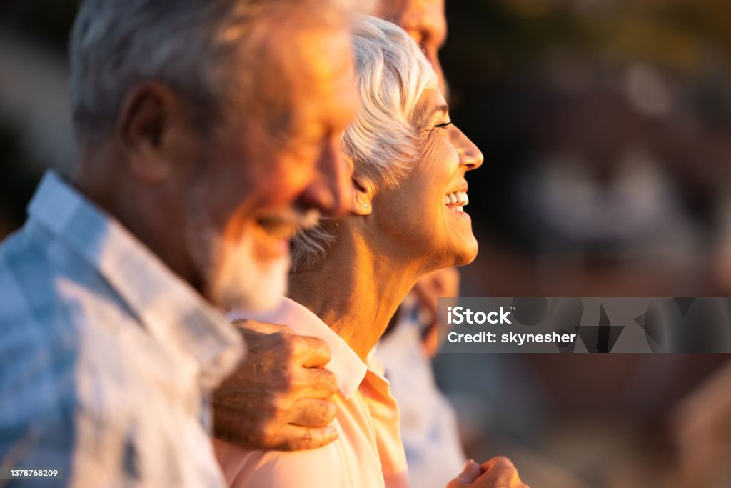 Happy senior woman walking with friends in nature. Happy mature woman walking embraced with her friends in nature. Senior Adult Stock Photo