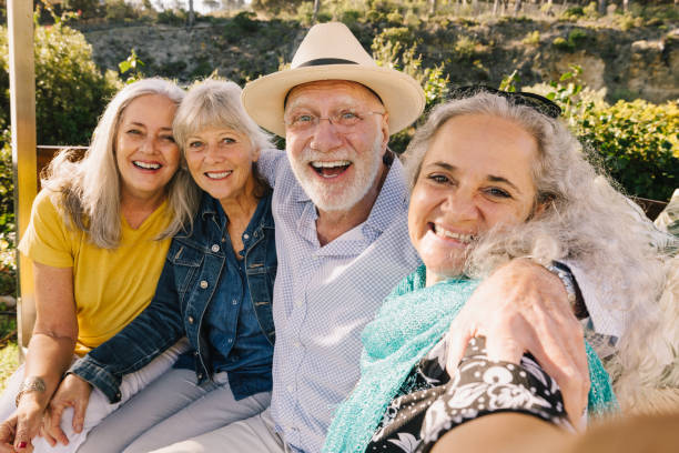 excited senior friends taking a selfie together during vacation - tourist resort fotos imagens e fotografias de stock