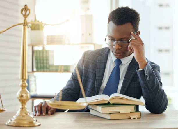 tiro de um jovem advogado lendo um livro no trabalho - book business business person formalwear - fotografias e filmes do acervo