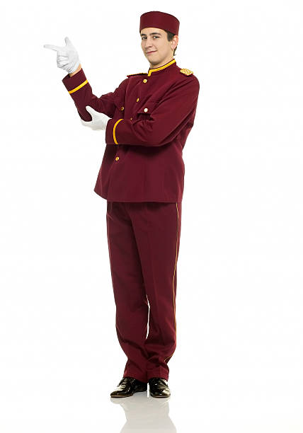 usher points at ?? Usher with red uniform and white gloves points at ??. bellhop stock pictures, royalty-free photos & images