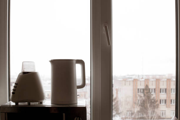 istock kettle and coffee grinder standing on a microwave, against a window with a blurred white background 1378815820