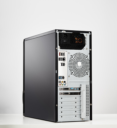 Rear view of a modern desktop pc tower unit on white background
