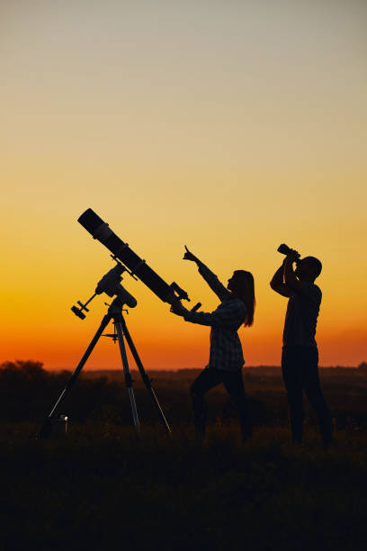 istock Couple stargazing together with a astronomical telescope. 1378842099