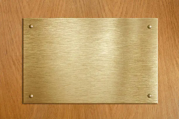 Wooden plaque with gold or brass plate