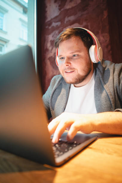 istock man freelancer working on laptop in cafe eating burger and drinking tea 1378853507