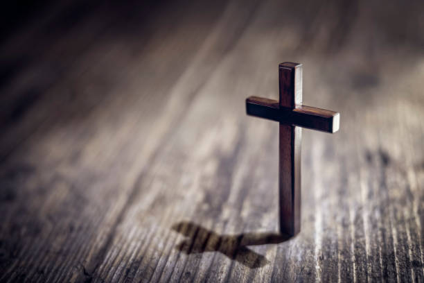 Religious crucifix cross upright on wooden table background Religious crucifix cross upright on wooden table background with copy space revival stock pictures, royalty-free photos & images