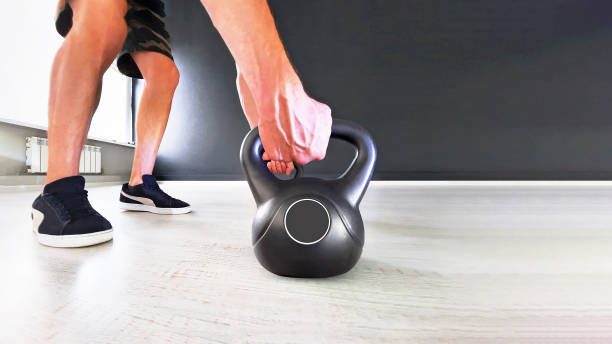 istock Black cast iron kettlebell on a black background. Black kettle bell with hand 1378888090