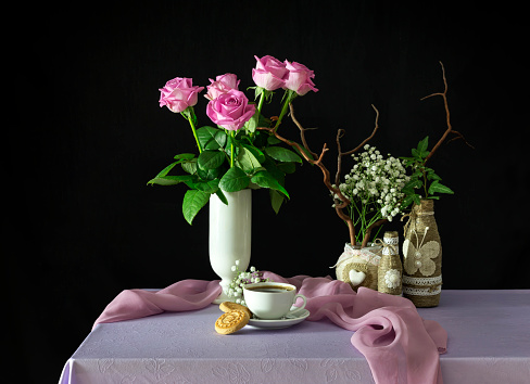 Still life with pink roses and coffee on a table close-up