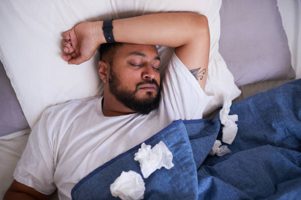 istock An overhead shot of a sick man sleeping in bed surrounded by tissues 1378918781