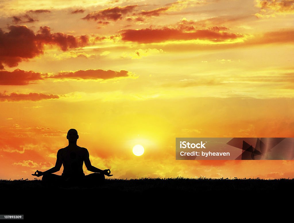 Yoga meditation at sunset Yoga meditation in lotus pose by man silhouette at sunset sky background. Free space for text and can be used as template for web-site Yoga Stock Photo